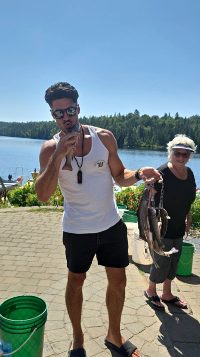 souvenir_real-masse_27 Jeune homme embrassant un poisson à la pourvoirie Au Pays de Réal Massé
